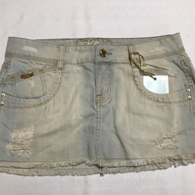 Minissaia Jeans Adulto Feminino Modelo com barra desfiada e detalhes em "rasgos" Fecho em zíper e botão, bolsos frontais e traseiros Tamanho 40, 42 e 44 Marca Fx2 Denim Composição: 100% Algodão