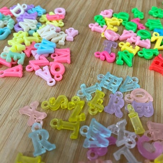 Pingente letra colorida 14X9mm - Pacote de 30g com aproximadamente 110 unidades
