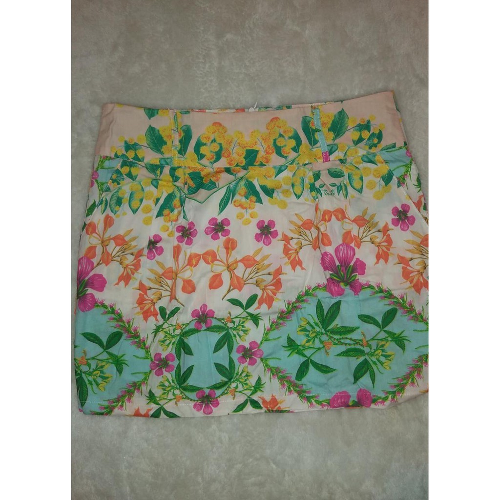 BS 465 - Saia Floral, confeccionada em algodão, tamanho 42. Possui bolsos dianteiros (modelo faca) e preguinhas que valorizam a silhueta. Cós largo com passador.