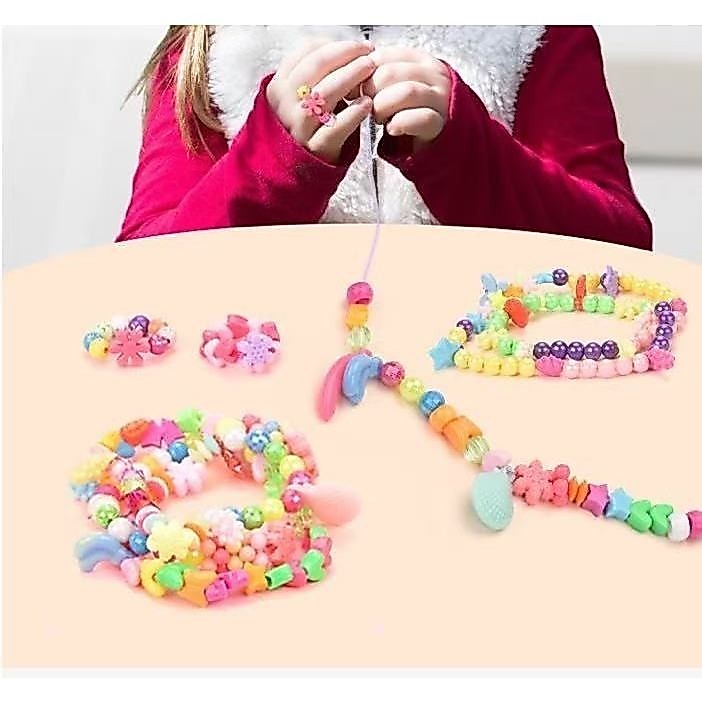 Menina faz pulseiras DIY com miçangas – criação artesanal criativa, atividade educativa infantil com bijuterias variadas — imagem 2 de 2