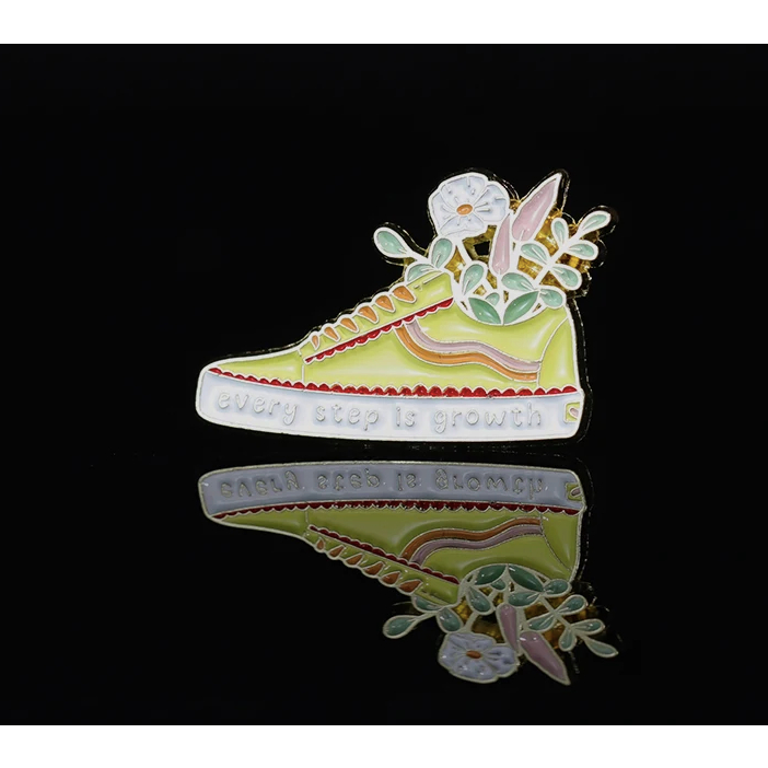 lindo broche em forma de tenis da vans com o escrito cada passo é crescimento em inglês