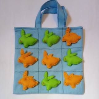 Jogo da velha páscoa, jogo pedagógico e educativo com peças de coelhos verdes e laranja, bolsa azul, dia das crianças