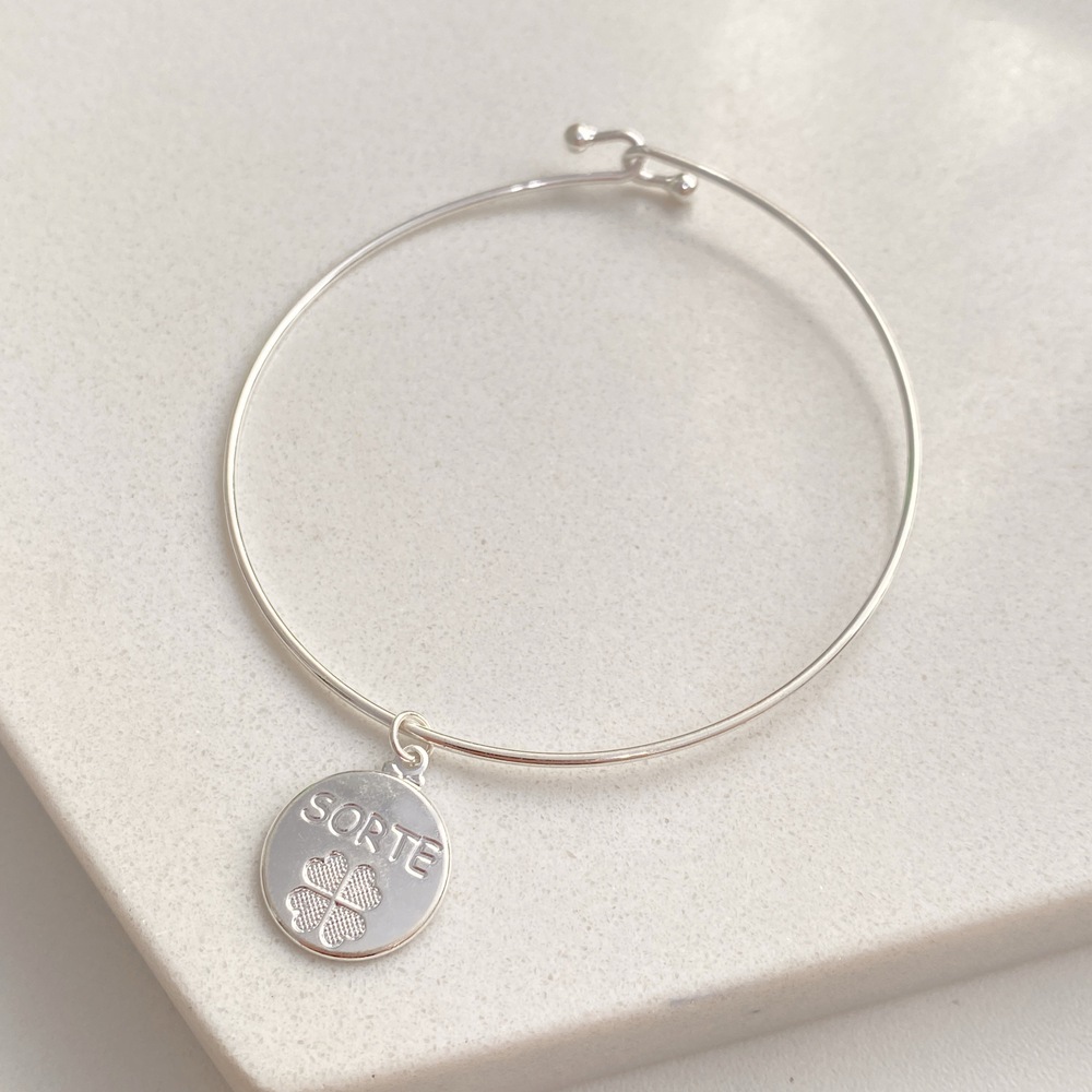 Pulseira bracelete em aro rígido com pingente de medalha com desenho de trevo e palavra Sorte folheada a ouro ou prata