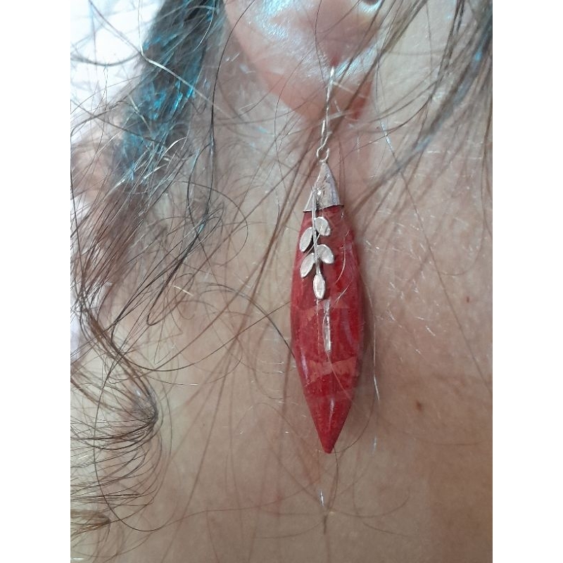 brinco de anzol de coral trabalhado na prata envelhecida 925. A peça de coral é em formato navete,encaixada em uma base de prata , com um galho sobre o coral.
