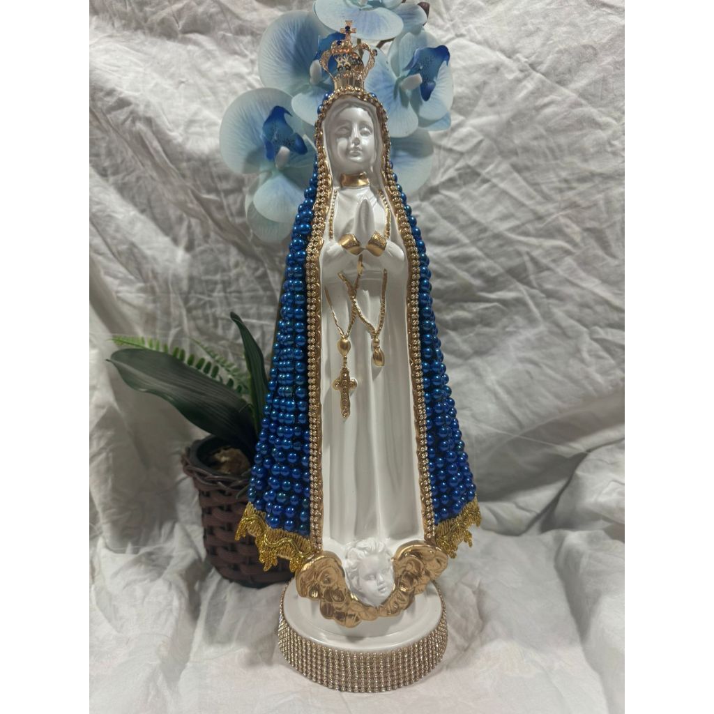 Imagem Nossa Senhora Aparecida 40cm com coroa de metal e com o manto revestido de pérola dourada e detalhada com strass dourado. Também temos outra variação om o manto pintado de azul metalizado e finalizado com verniz tb detalhada com strass dourado