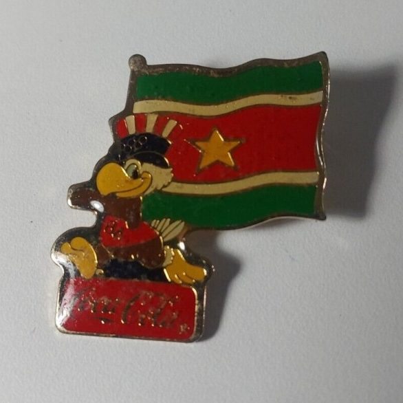 Pin Broche Oficial Olimpiadas de Los Angeles USA 1980 Coca Cola Mascote Águia c/ Bandeira do Suriname - Raro