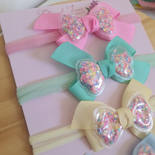 Laço na faixinha de bebe colorida com detalhe brilho estilosa. em Oferta na Shopee