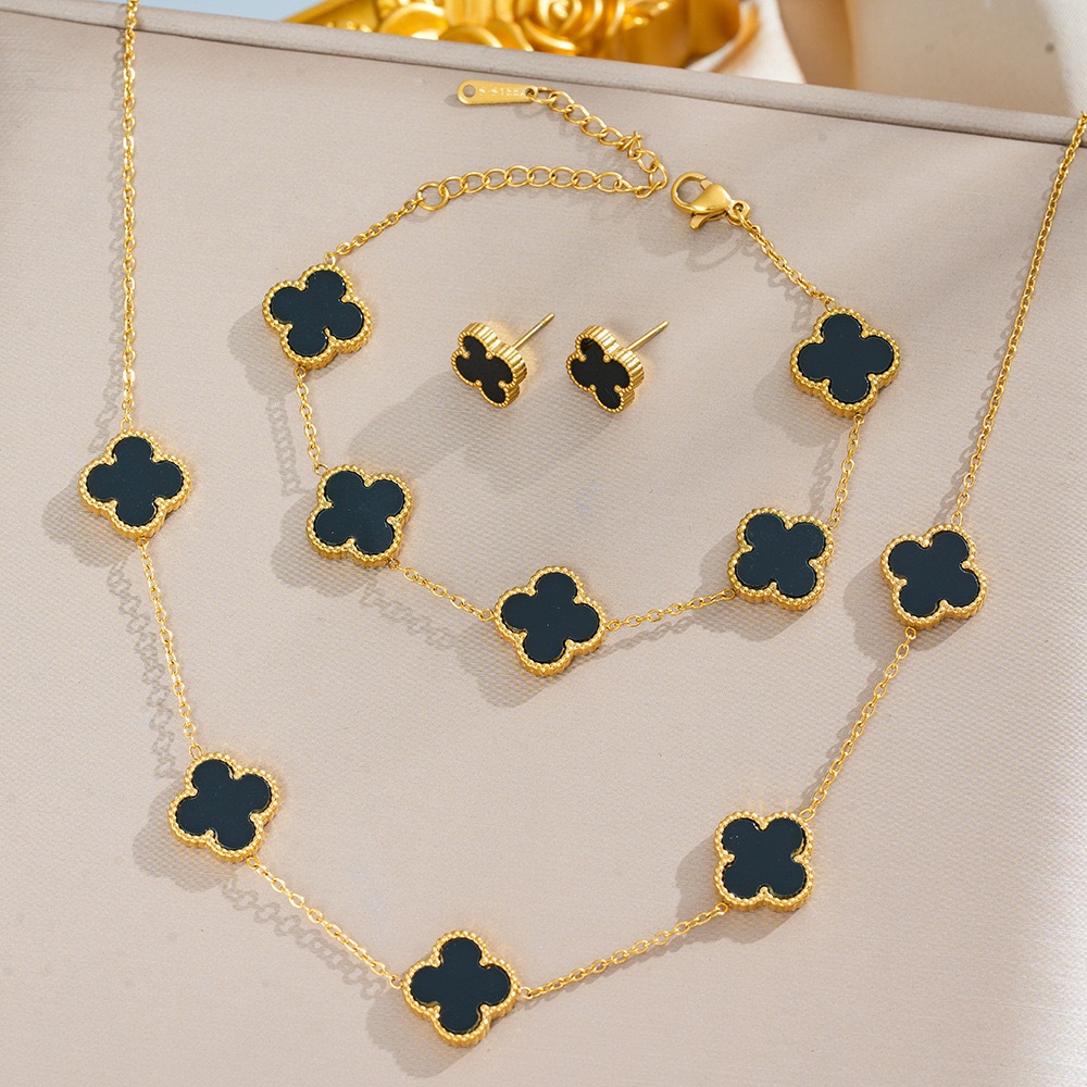 Conjunto de três peças de colar, pulseira e brincos de trevo de quatro folhas em aço titân...
