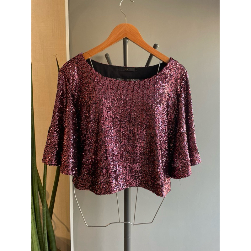 Blusa curta, manga larga, mini paetê, cor roxa.