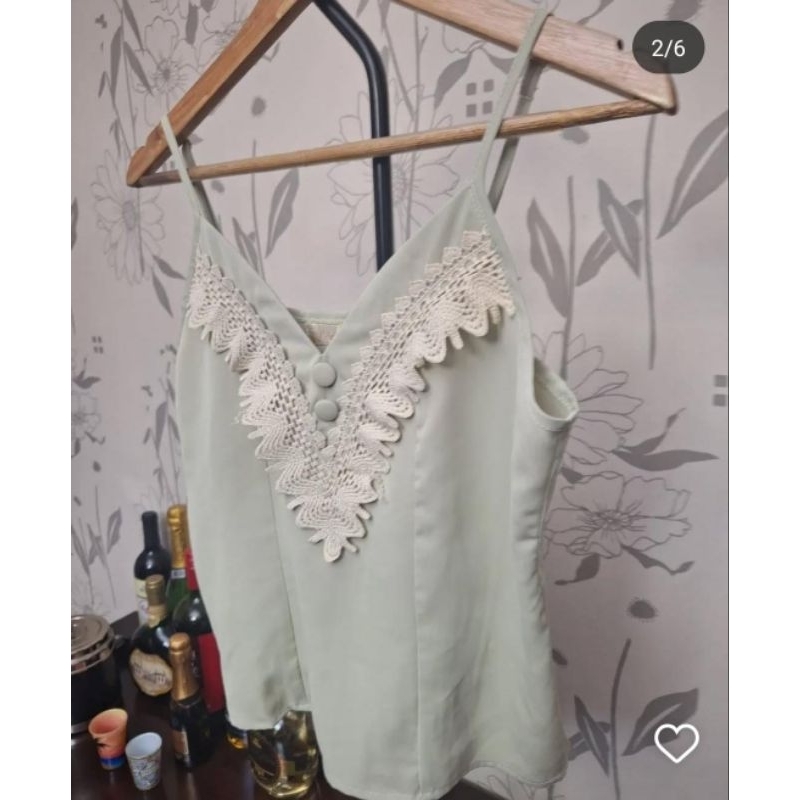 Blusa com alcinhas reguláveis, botões decorativos e detalhes em guipir. Tamanho P