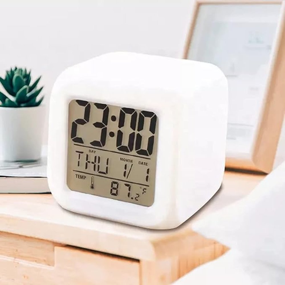Mini relógio despertador digital branco, compacto e moderno, com visor LED, ideal para mesa de cabeceira ou escritório.