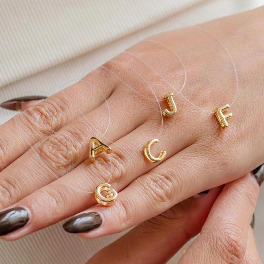 Colar Feminino Letra Passante no Fio de Nylon – Semijoia Banhada a Ouro 18K ou Prata 925 em Oferta na Shopee