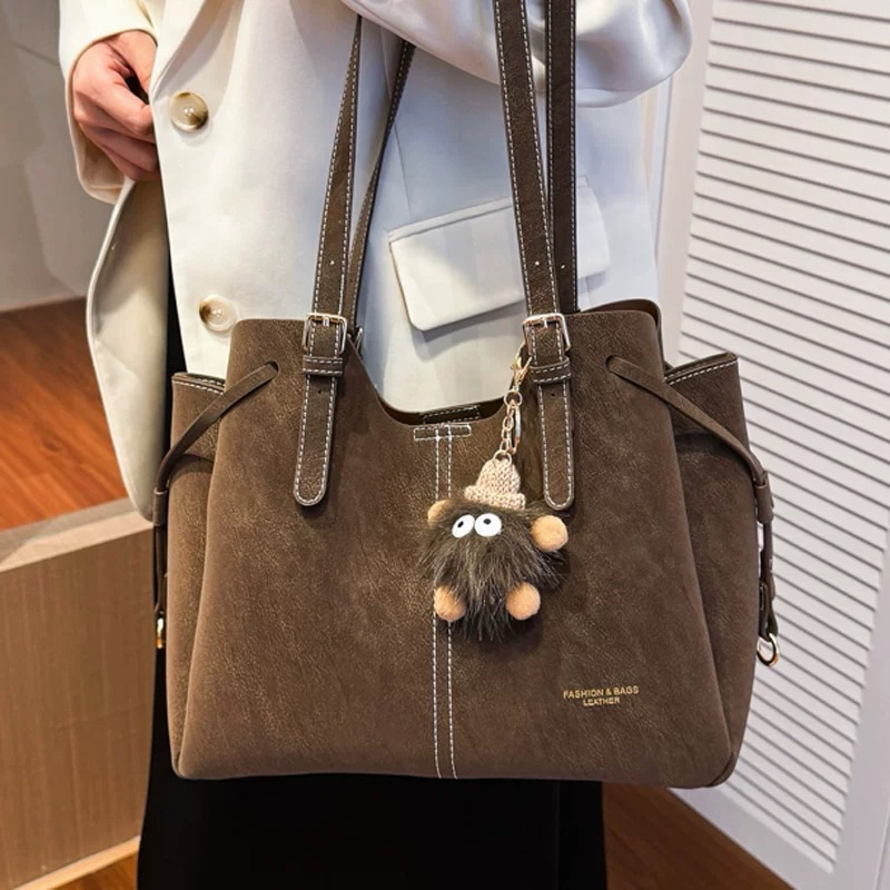 (002T)Bolsa feminina estilo retrô, grande capacidade, bolsa de mão, bolsa de ombro, pingente de pompom, estilo Maillard.