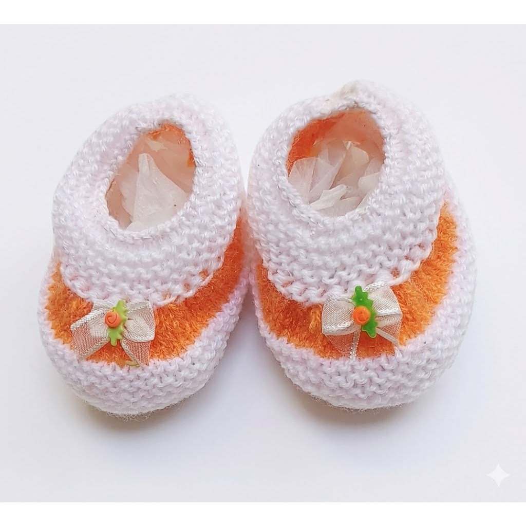 Sapatinho de tricô bebê branco com detalhes em laranja e laço decorativo