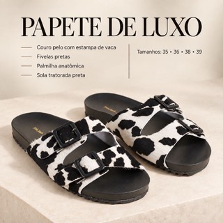 Papete em couro pelo com estampa de vaca com fivelas pretas. Palmilha anatômica e sola tratotada preta