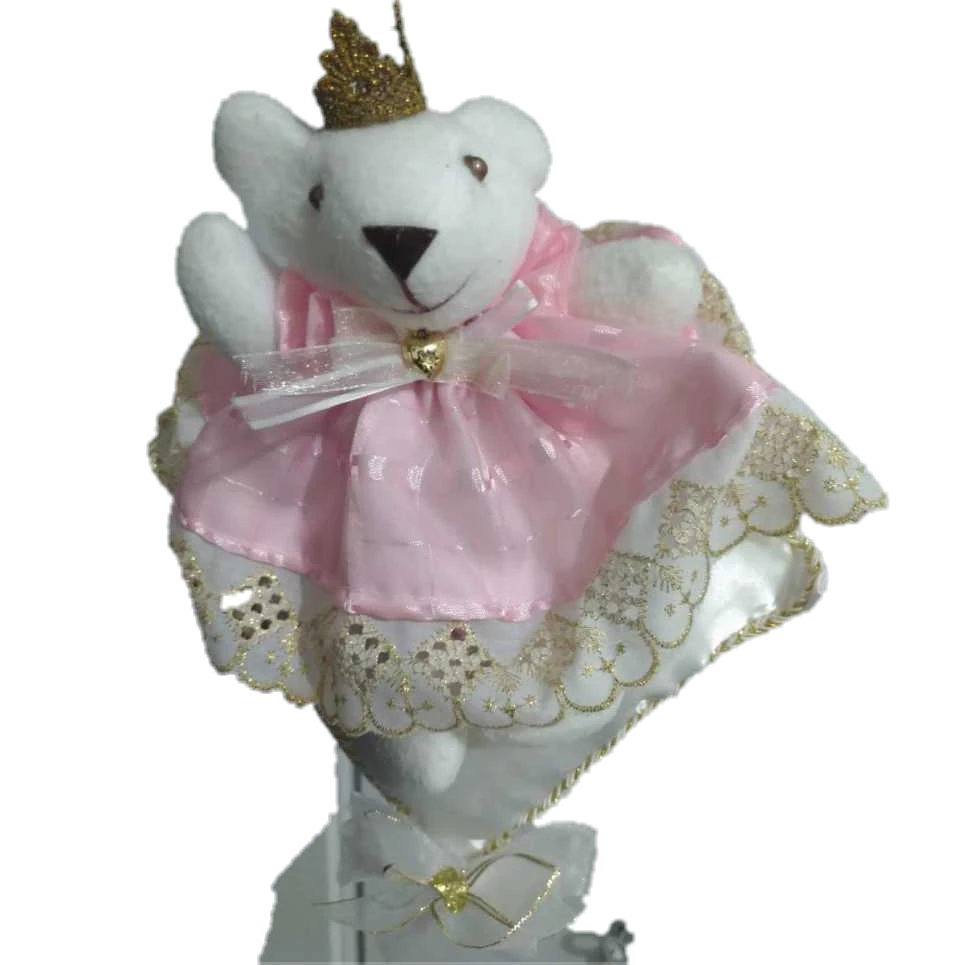 ursinha de pelúcia decorativa vestida de princesa com coroa dourada e vestido rosa em cima da almofada