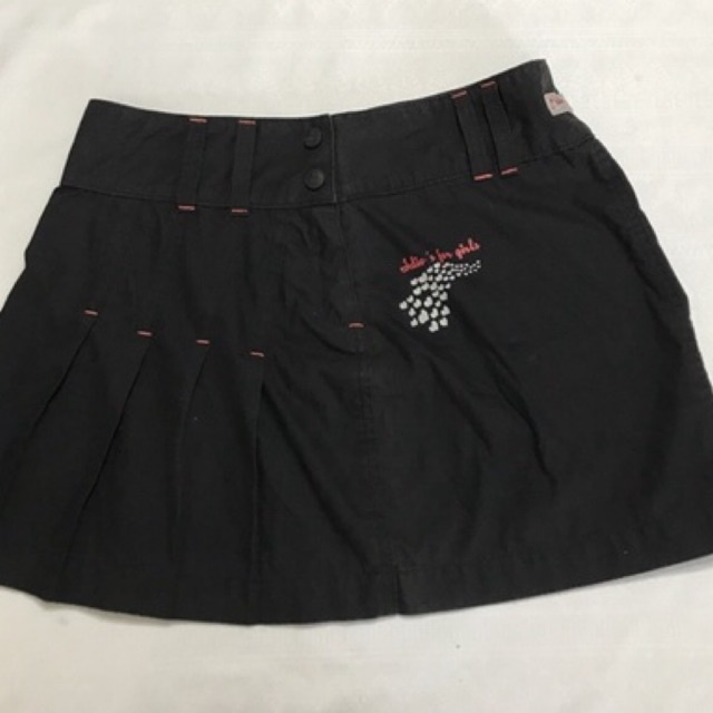 Minissaia Surfista Adulto Feminino  Modelo em tecido tactel, drapeado e com discreta estampa Cós largo, fecho em zíper e 2 botões Cor preto com costura discreto em laranja Tamanho 42 Marca Idio’s Composição: 81% Algodão e 19% Poliéster