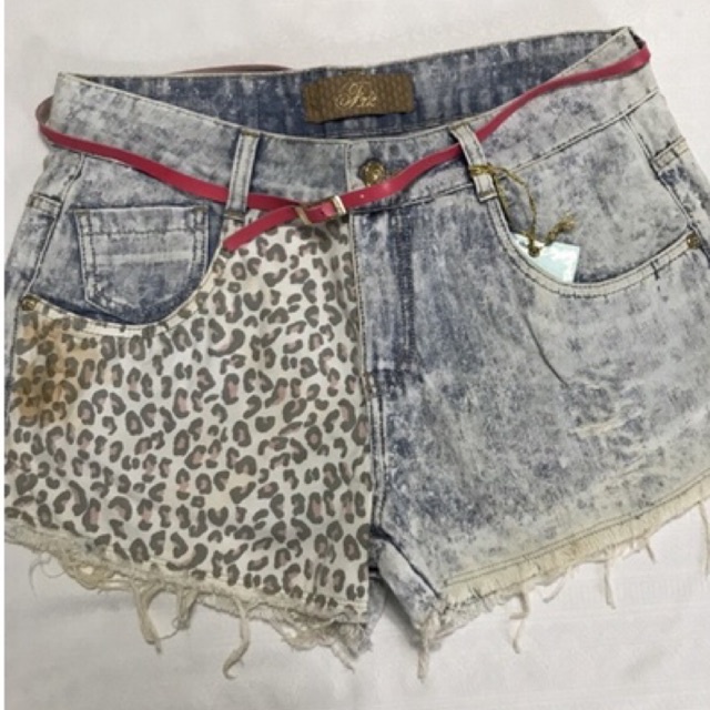 Shorts Bermuda Jeans Adulto Feminino Modelo com barra desfiada e detalhes em "rasgos" Jeans azul claro lavado com estampa de "Onça" de um lado Fecho em zíper e botão, bolsos frontais e traseiros Cinto rosa fino Tamanho 38 Marca Fx2 Denim