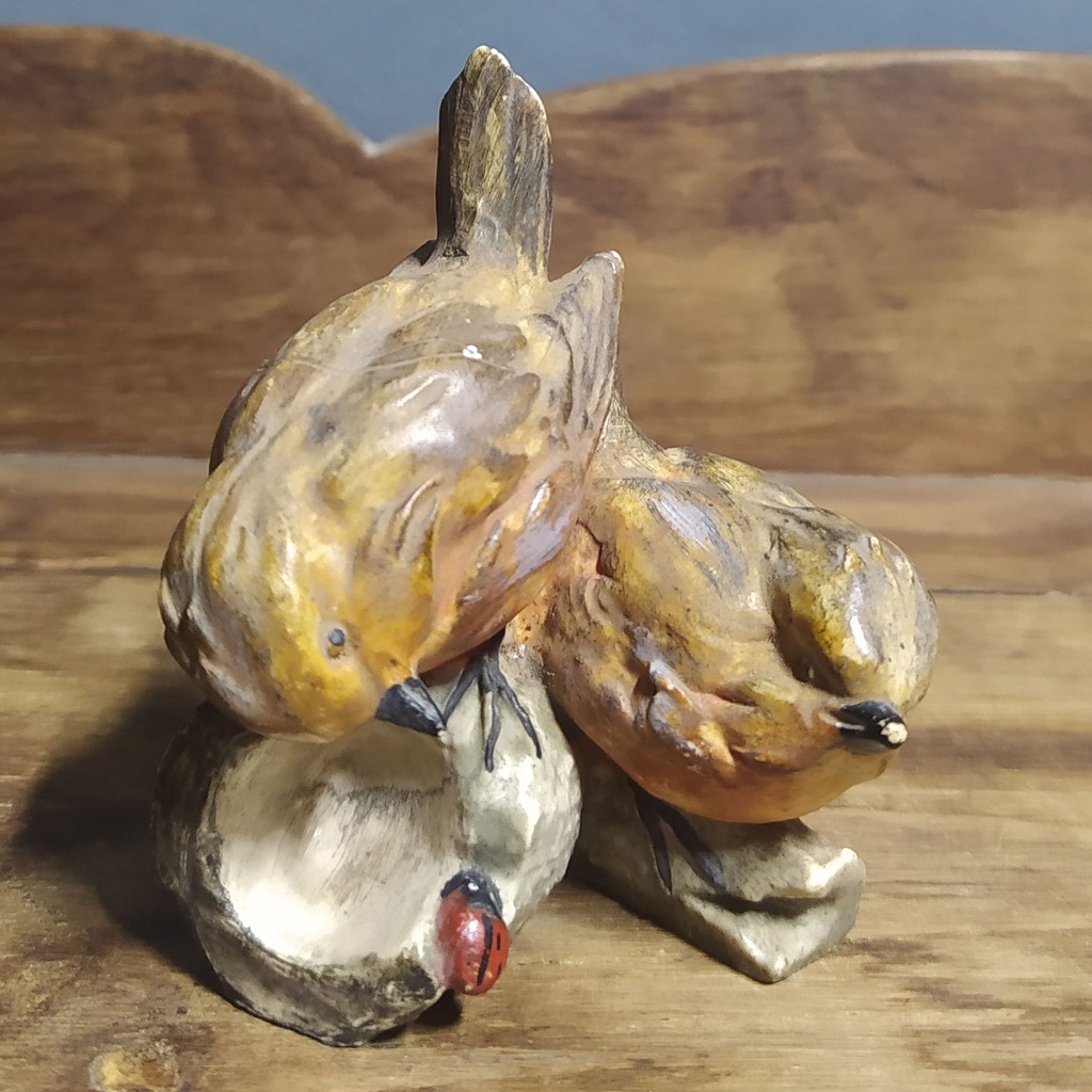 Graciosa escultura em porcelana com pássaros representados