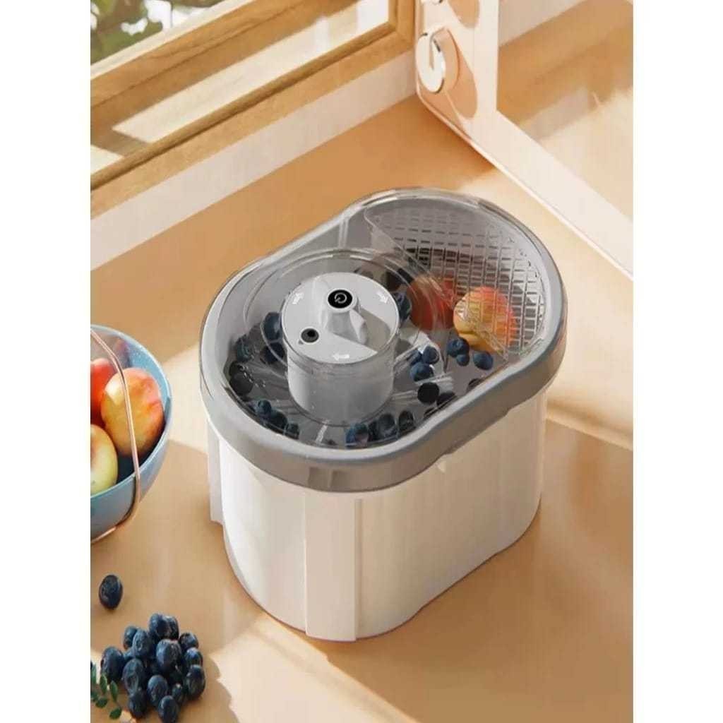 Máquina de lavar frutas e vegetais elétrica automática na cor branca com cesto cinza sobre uma bancada de cozinha