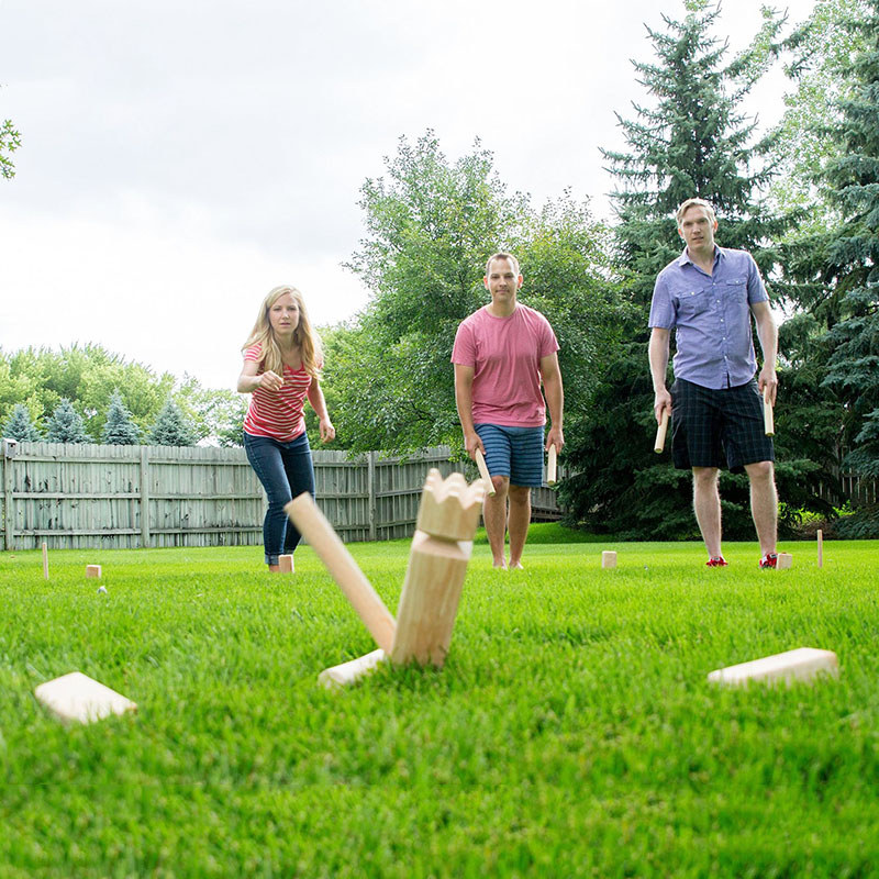 Kubb de madeira rei e soldado jogando jogo grupo expansão ao ar livre construção grama parque diversão lazer esportes