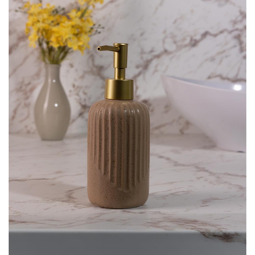 Porta sabonete líquido Lyor Noble de 350ml na cor marrom, feito de cerâmica com textura vertical e válvula dosadora dourada, posicionado sobre uma bancada de mármore ao lado de um vaso com flores amarelas.