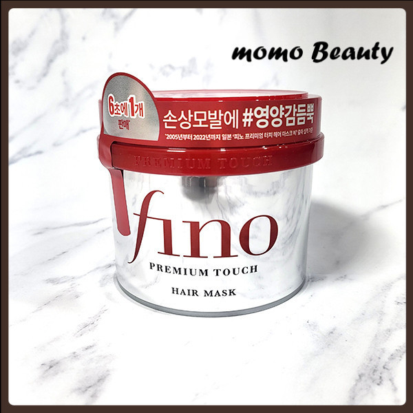Pote de máscara capilar Shiseido Fino Premium Touch de 230ml com tampa vermelha e corpo prateado sobre superfície de mármore