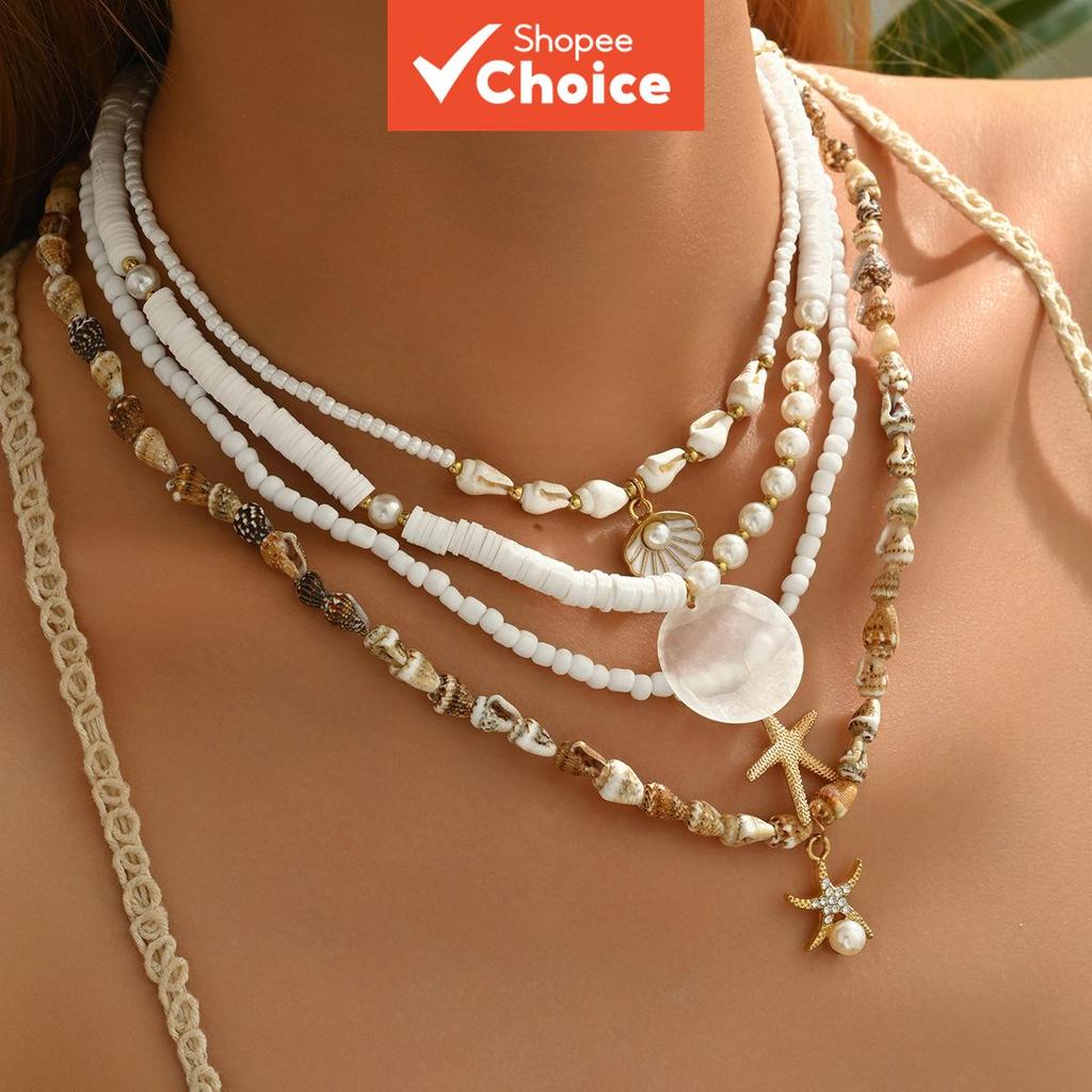 Colar de praia com estrela-do-mar, conchas e pérolas; feito à mão; várias camadas; destaque para o colar de pérolas;